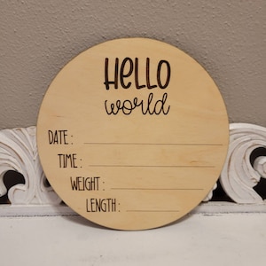 May include: A round wooden sign with the text "HELLO world" and blank lines for "DATE", "TIME", "WEIGHT", and "LENGTH".