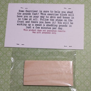 May include: A rectangular wooden block inside a clear plastic bag, accompanied by a white card with the text: Home Exerciser is sure to help you shed the pounds fast! This exercise block will have you on your way to skin and bones in no time at all.
