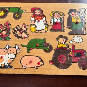 Può includere: Puzzle in legno a tema fattoria con illustrazioni colorate di un trattore, gallo, mucca, maiale e contadini. I pezzi del puzzle sono dai colori vivaci, tra cui un trattore verde e un trattore rosso. Progettato per bambini piccoli.