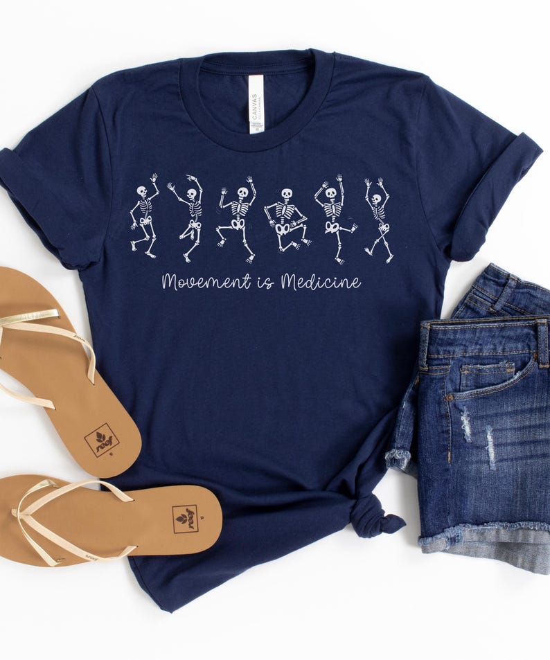 K&ouml;nnte beinhalten: Ein marineblaues T-Shirt mit einer wei&szlig;en Grafik von tanzenden Skeletten und dem Text "Bewegung ist Medizin".