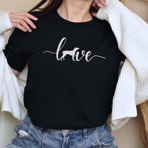 May include: Black t-shirt with a white silhouette of a dog and the word "love" written in cursive.
