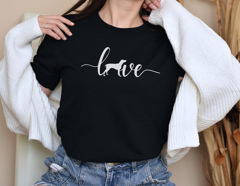 May include: Black t-shirt with a white silhouette of a dog and the word "love" written in cursive.