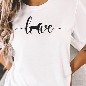 May include: White t-shirt with a black silhouette of a dog and the word "love" written in cursive.