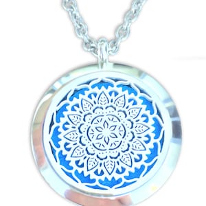 May include: A silver pendant necklace with a round, blue and white mandala design. The pendant has a small opening on the side for adding essential oils.
