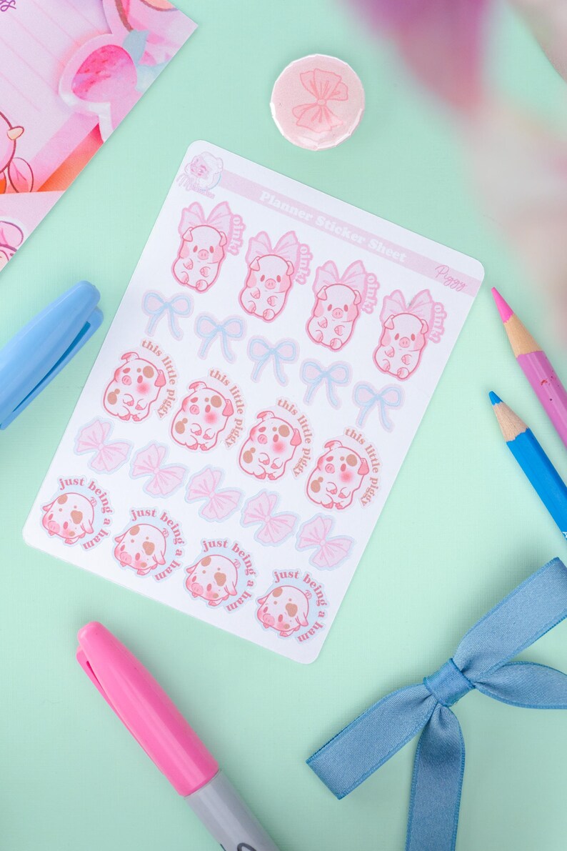 Puede incluir: Una hoja de pegatinas para planificador con ilustraciones de cerdos rosas con lazos y texto que dice "this little piggy" y "just being a ham". Las pegatinas est&aacute;n sobre un fondo blanco, con un fondo verde claro y rosa.