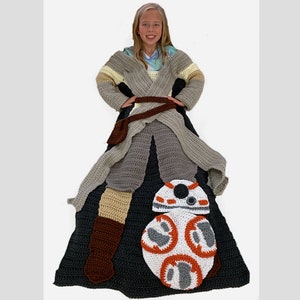 May include: A crocheted blanket featuring a Star Wars character, BB-8, in the center. The blanket is gray, black, white, orange, and brown. A person is wearing a crocheted robe that matches the blanket.
