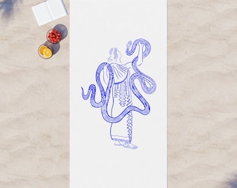May include: A white beach towel with a blue line drawing of a person holding a snake. The snake is coiled around the person's body and head. The towel has a fringe border.
