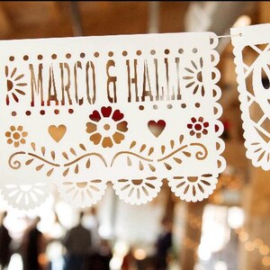 May include: White paper banner with a cut-out design, featuring the text "Marco & Hall" in a decorative font.