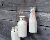 Hanging wall vases with 'antique copper' chains. Porcelain ceramic vases to hang from garden and indoor walls. Bottle vase design.