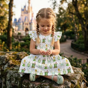 Vestido encantador da Sininho com babados e efeito pó de fada, asas de fada e estampa de garrafa branca, perfeito para aniversariantes da Disney com tema de férias de verão.