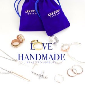 May include: An assortment of handmade jewelry, including rings, necklaces, and a bracelet, is displayed on a white surface. The word "LOVE" and "HANDMADE" are featured in the image. The jewelry includes silver, gold, and rose gold tones, with some pieces featuring intricate designs.