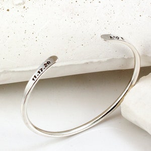 May include: Silver bangle bracelet inscribed with "11.17.20" on one side and "A♥E" on the other.