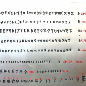 May include: A metal sheet displaying various fonts and symbols for stamping. The image includes uppercase and lowercase alphabets in different sizes, along with numbers and symbols. Text indicates sizes in millimeters.