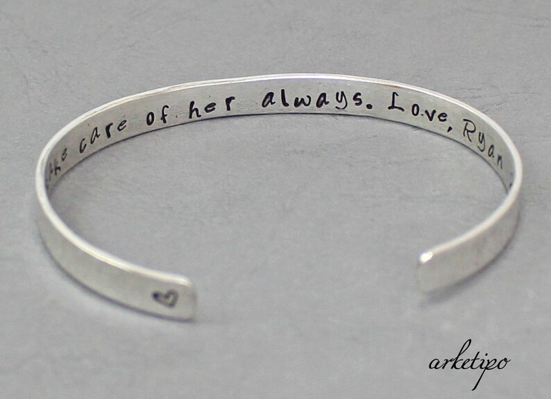 Op de afbeelding: Zilveren armband met de inscriptie "Zorg altijd goed voor haar. Liefs, Ryan" en een klein hartje gegraveerd aan de binnenkant.