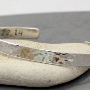 Op de afbeelding: Een zilveren gehammerde armband met de datum "2.22.14" gegraveerd aan de binnenkant.