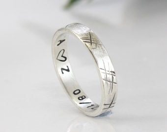 Peut inclure: Une bague en argent avec une finition brossée et une inscription qui dit "A ♥ 2 08/11".