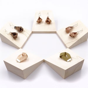 May include: Five wooden display stands with different colored fabric earrings and bracelets. The stands are arranged in a hexagon shape.