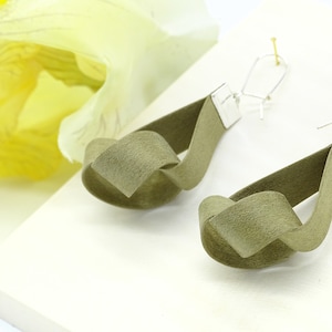 May include: A pair of olive green knotted fabric earrings with silver hooks.
