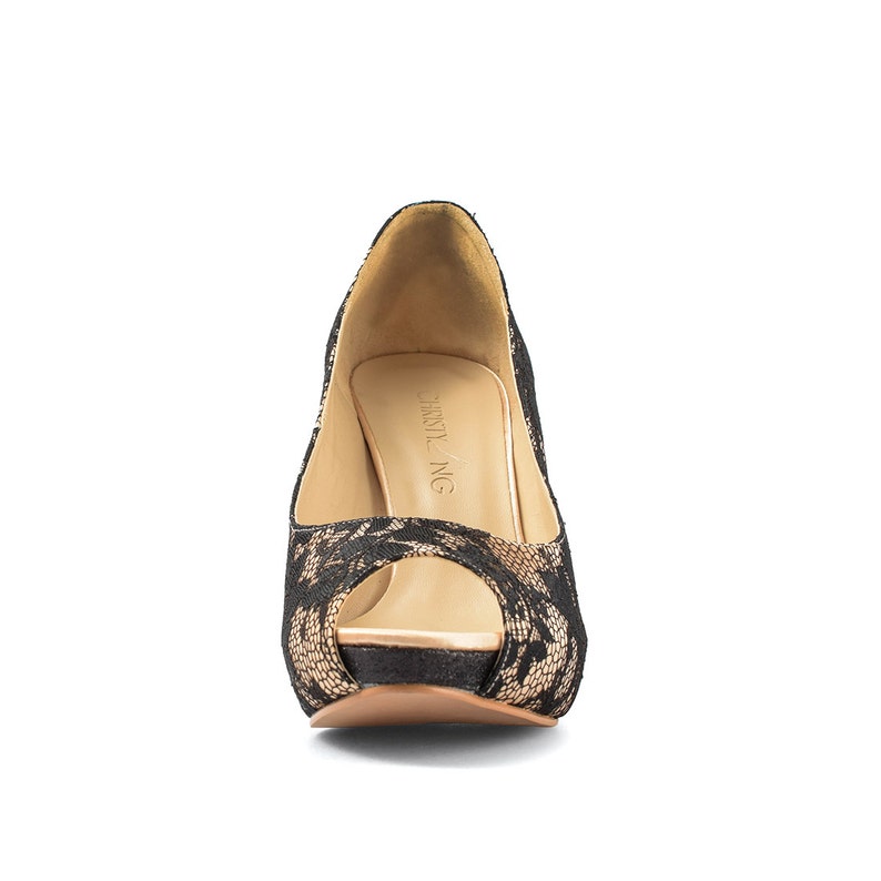 Op de afbeelding: Zwarte peeptoe hakken met een kantontwerp en een gouden platform. De hakken hebben een "CHLOE NG" label aan de binnenkant.