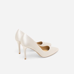 May include: A pair of ivory satin high-heeled pumps with a pointed toe.