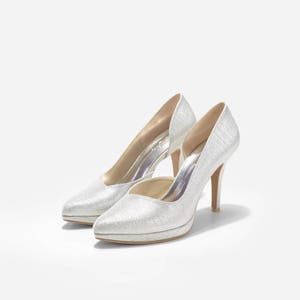 May include: A pair of silver glitter high-heeled pumps with pointed toes.