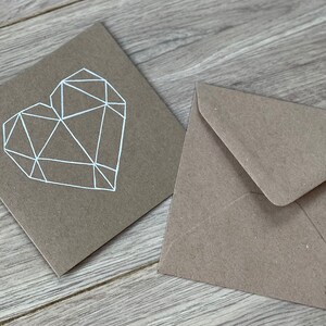 May include: A brown card with a white geometric heart design and a matching brown envelope.