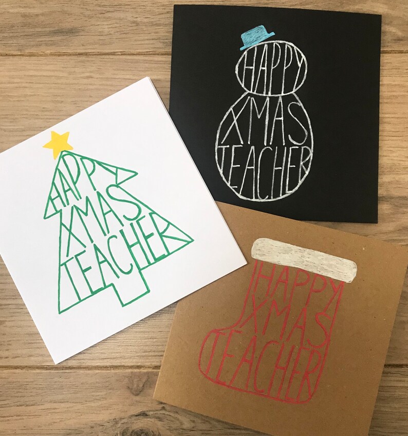 May include: Three Christmas cards with the text "HAPPY XMAS TEACHER". One card is white with a green Christmas tree design, another is black with a snowman, and the third is brown with a stocking.