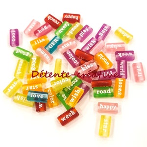 May include: Assortment of colorful rectangular tiles with words printed on them. The words include "star", "cool", "love", "wish", "color", "happy", "road", "week", "true", "world", "hope", "sing", "play", "kiss", "good", "reach", "name", "GER", "ever", "pet", "why", "sweet", "ish".
