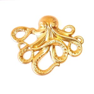 May include: A gold-colored octopus wall decor with eight tentacles. The octopus is made of a smooth, shiny material and has a detailed design.