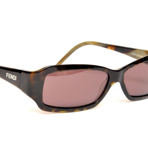 May include: Brown and tortoise shell sunglasses with brown lenses. The sunglasses have the word "FENDI" written on the side.