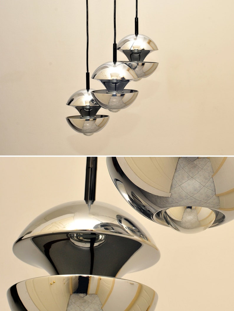 Peut inclure: Un ensemble de trois lampes suspendues chrom&eacute;es de forme sph&eacute;rique. Chaque lampe est compos&eacute;e de deux demi-sph&egrave;res qui sont reli&eacute;es par le haut.