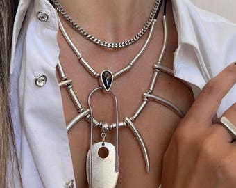 Collar con dijes puntiagudos de Swarovski en capas de estilo africano: cuero negro, cristal de Swarovski y cadena de acero inoxidable.