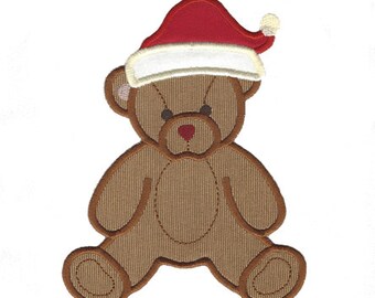 May include: A brown teddy bear patch featuring a red and white Santa hat. The bear has dark brown stitched eyes and a small red heart-shaped nose. The design is outlined with a dark brown border, showcasing a textured fabric appearance.