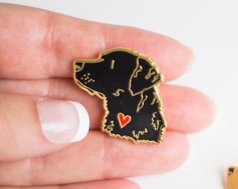 May include: Gold-tone enamel pin featuring a black silhouette of a dog's head with a red heart on its chest.