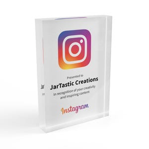 May include: A clear acrylic award with the Instagram logo in the center. The award reads "Presented to JarTastic Creations" and "In recognition of your creativity and inspiring content." The Instagram logo is a gradient of orange, pink, and purple.