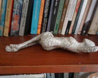 A paper mache sculpture of a young woman laying on her back