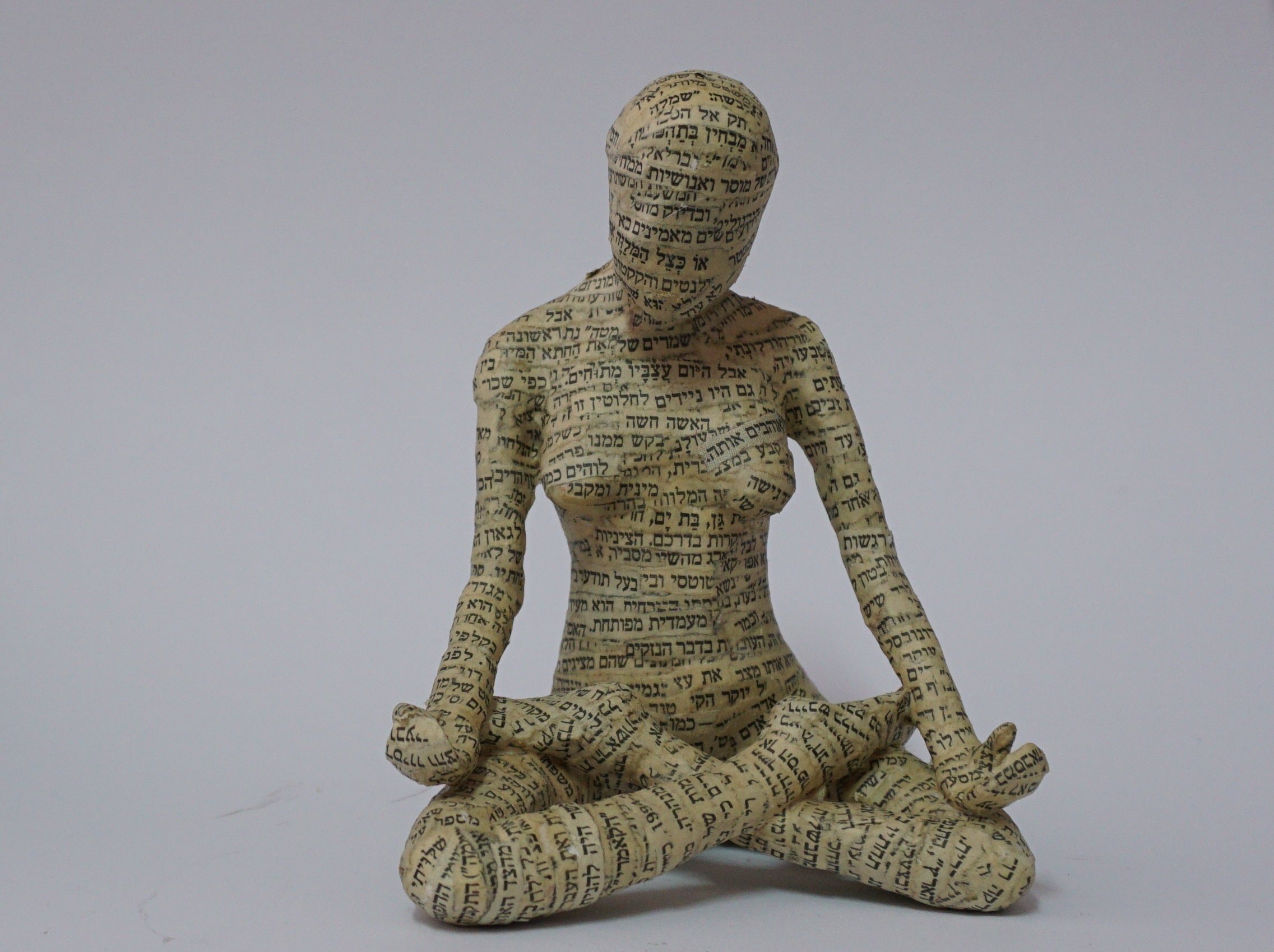 Una escultura de papel mache de una mujer practicando yoga. Etsy