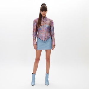 May include: A white ceramic mug with a black handle and the text "But First, Coffee" in a bold, black font. The mug is on a wooden surface. The mug is approximately 10 cm tall.