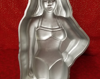 Mujer en traje de baño con forma de molde para pasteles