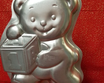 Teddy Bear holding wooden block cake pan