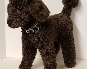 Rufus, el caniche francés creado para una agencia de publicidad para una campaña. Pelo sintético rizado marrón con cuello de cuero. Veinte pulgadas de alto.
