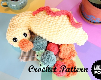 May include: A crocheted sushi-themed amigurumi set. The set includes a large yellow sushi roll with black eyes and an orange beak, and several smaller sushi pieces in various colors. The words "Crochet Pattern" are visible.