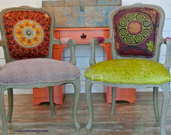 May include: Two vintage chairs with ornate frames, one with a gray and white chevron patterned seat and a colorful patterned back, the other with a lime green velvet seat and a colorful patterned back.