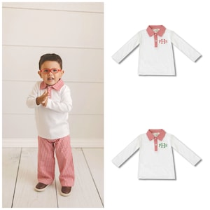 May include: White long-sleeved polo shirt with a red and white checked collar and cuffs. The shirt has a green embroidered monogram "PHS" on the chest.