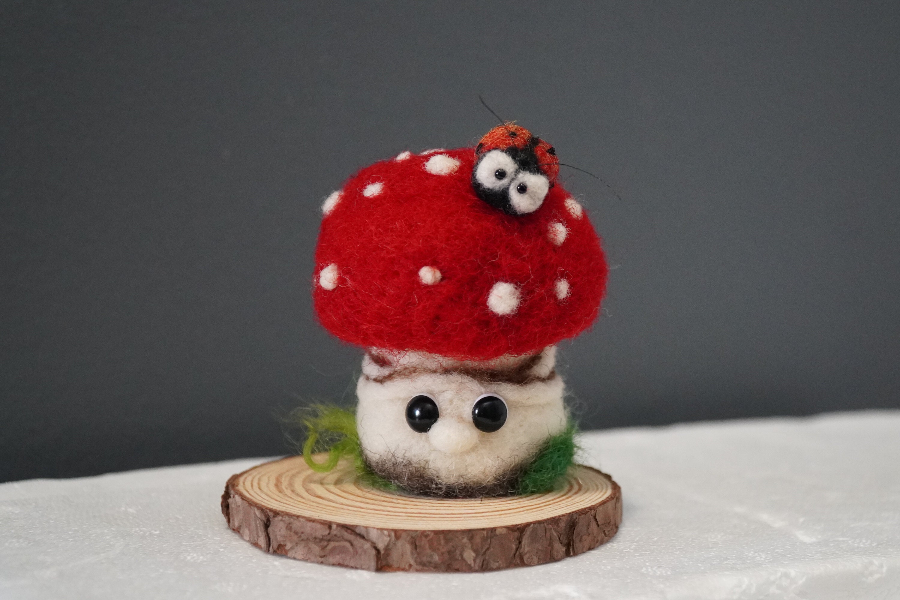 Cute chubby fungi on a real wood stump wool felted mushroom sculpture with a tiny ladybug