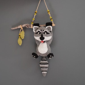 Crochet raccoon hanging on a driftwood branch with leaves one of a kind unique wall art driftwood hanging decor