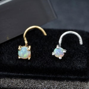 May include: Two nose rings with opal stones. One ring is gold and the other is silver.