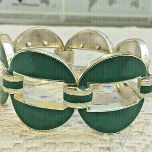 May include: A silver and green bracelet with a linked chain design. The bracelet is made of metal and has a green enamel finish.