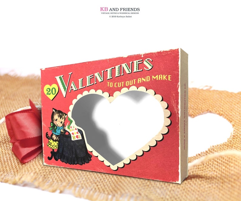 May include: A red box with a heart-shaped cutout and the text "20 Valentines To Cut Out And Make". The box features a cartoon illustration of a cat wearing a dress and holding a heart-shaped card.