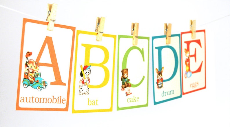 May include: A colorful alphabet chart with illustrations and words for each letter. The letters are A, B, C, D, and E. The words are automobile, bat, cake, drum, and eggs.